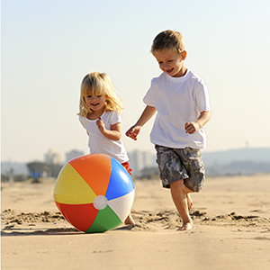 two kids playing with a beach ball