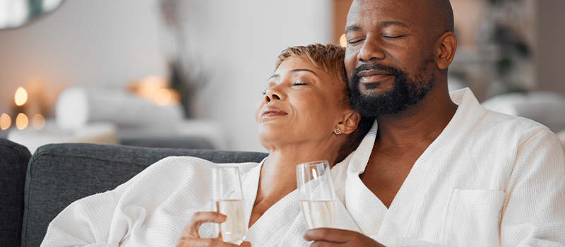 couple relaxing in robes and drinking champagne