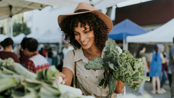 Lady at the farmers market picking through Kale