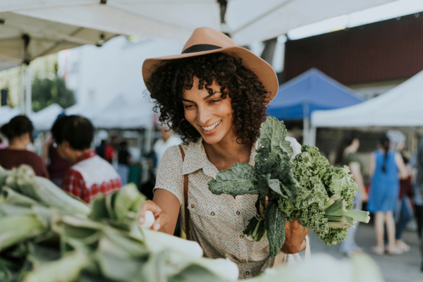 Woman at the farmers market picking through Kale